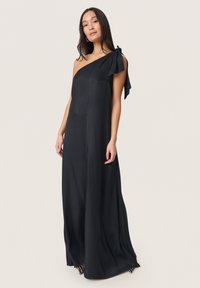 Černé maxi šaty na jedno rameno s mašlí na rameni, hladkým materiálem a splývavým střihem. Minimalistický design s elegancí.