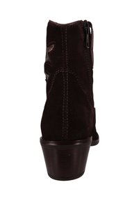 Brązowy zamszowy botek na kostkę z zamkiem błyskawicznym, obcasem na słupku i ozdobnym przeszyciem. Z tyłu znajduje się dekoracyjny wzór.