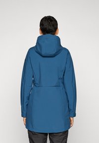 Blå vanntett jakke med hette, med en tilpasset design og lange ermer. Materialet ser glatt ut med en mid-length kutt.