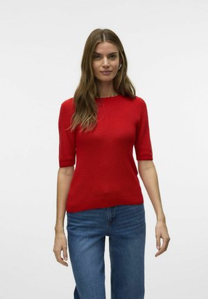 Rød strikket T-shirt med kortærmer, rund halsudskæring og ribbet tekstur, parret med blå jeans. Enkel design, ingen mønstre eller pynt.