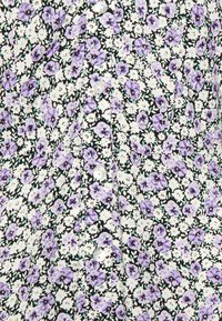 Vestido floral com fundo preto, apresentando pequenas flores roxas e brancas. Tem um fecho de botões na frente e um tecido suave e texturizado.