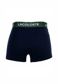 Shorts di cotone blu navy con vita elastica verde, con la scritta "LACOSTE" stampata in bianco. Design semplice con una vestibilità classica e senza motivi.