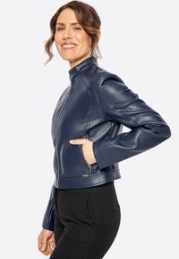 Giacca di pelle blu navy con colletto alto, chiusura frontale con zip e tasche laterali. Presenta un design aderente e una texture liscia.
