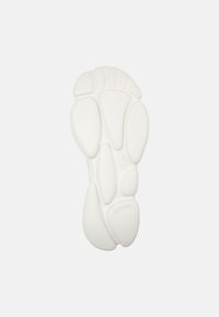 Sole di sneakers in gomma bianca con un motivo testurizzato caratterizzato da rientranze arrotondate e scanalature per una migliore aderenza. Design semplice ed ergonomico.