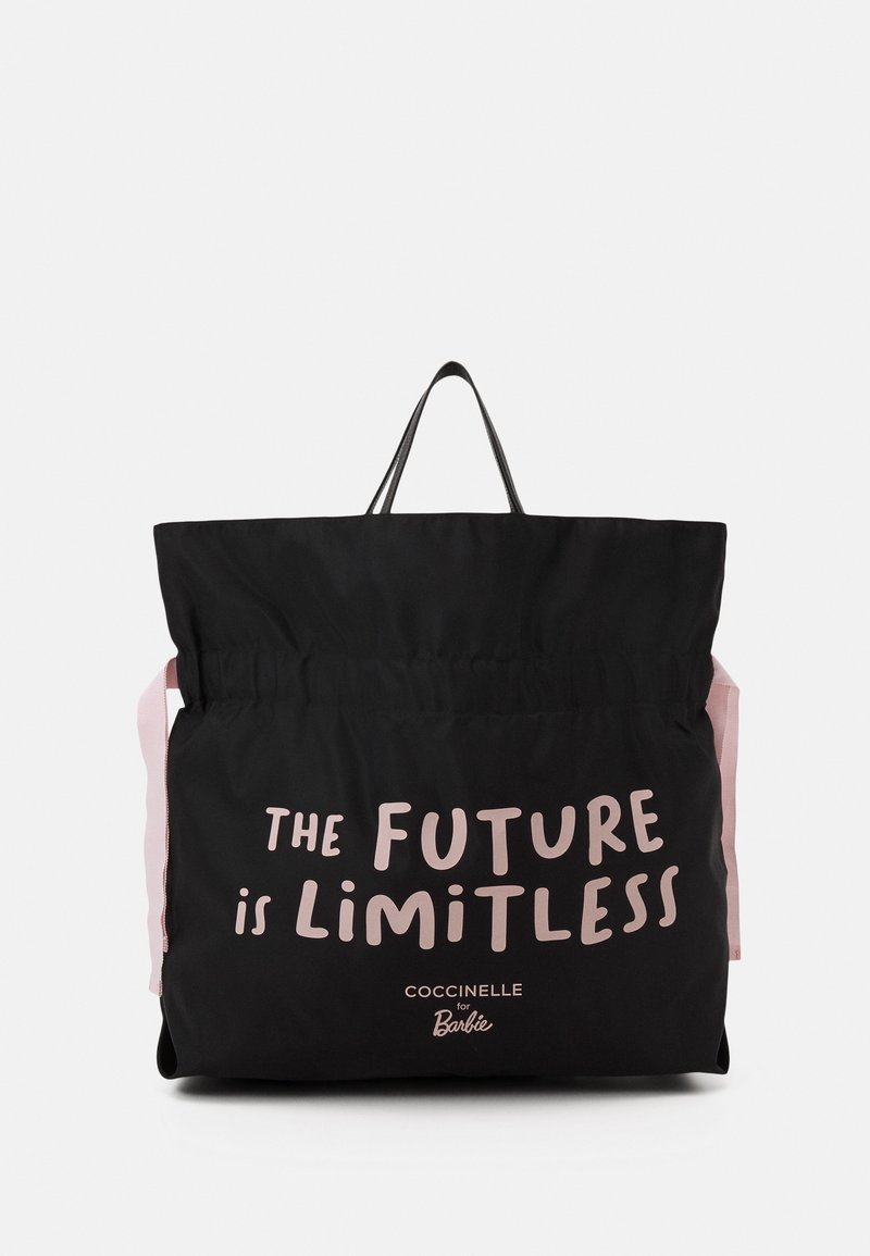 Sac cabas noir avec poignées roses et texte « L'avenir est sans limites » et « Coccinelle pour Barbie » imprimés sur le devant.