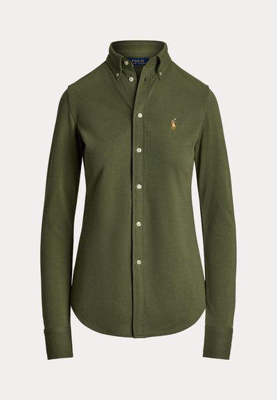 Olivovo zelená košeľa s dlhými rukávmi a zapínaním na gombíky z mäkkej látky, s klasickým golierom a vyšívaným logom na ľavej strane hrudníka.