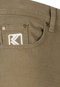 Tissu khaki avec une finition texturée, comportant une petite poche avec un logo brodé en blanc et des accents en bronze.