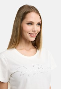 Witte katoenen T-shirt met een ronde halslijn, voorzien van zilveren belleggingtekst "Bruno Banani" en "NOT FOR EVERYONE" eronder, korte mouwen.