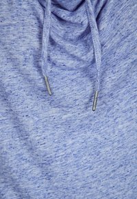 Jasnoniebieska bluza z kapturem o melanzowanym wyglądzie, z zebranym dekoltem i sznurkiem w srebrnym kolorze. Miękki materiał z casualowym fasonem.