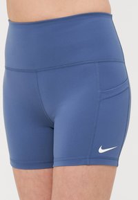 Shorts de sport bleu marine à taille haute, fabriqués dans un matériau extensible, dotés d'une poche latérale et d'un logo blanc sur la cuisse.