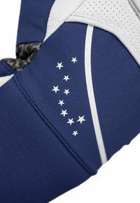 Tejido azul con una superficie texturada presenta acentos blancos y un diseño de estrellas dispuestas en un patrón curvado. Material blanco perforado visible.