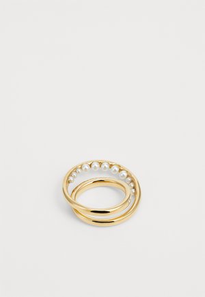 Anello d'oro a doppia fascia con una fascia che presenta una fila di piccole perle bianche su uno sfondo bianco.