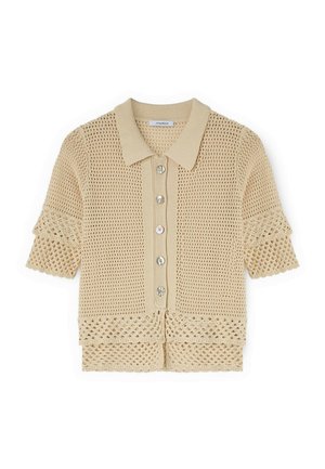 Beige kurze Häkelstrickjacke mit Kragen, Knopfleiste vorne und dekorativen offenen Strickmustern an Ärmeln und Saum.