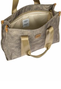 Grand sac fourre-tout en tissu texturé beige tricoté, avec des poignées dorées et un dessus ouvert montrant un intérieur clair avec l'étiquette Bric's.