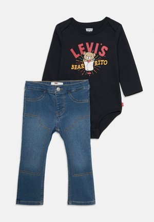 Bodysuit noir à manches longues pour bébé avec le slogan "Levi's Bearrito" et un graphique d'ours, associé à un jean en denim bleu pour bébé avec des détails de couture.