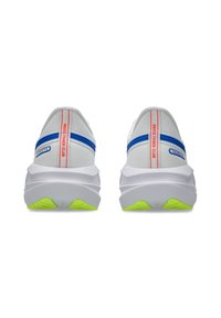 Baskets de course blanches avec des accents bleus, dotées d'une semelle plus épaisse avec des sections vert fluo et un marquage rouge à l'arrière et sur les côtés.