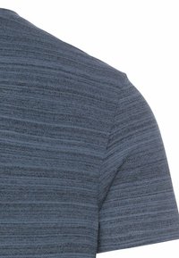 Marineblå kortærmet t-shirt med et tekstureret, stribet mønster og rund hals. Stoffet ser blødt og let ud.