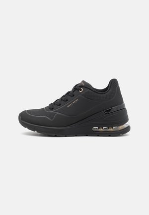 Zapatilla negra Skechers con cordones delanteros, suela amortiguada con aire y parte superior perforada para mayor transpirabilidad, mostrada de perfil.