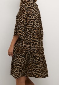 Leopardenmusterkleid mit gestuftem Design, kurzen Ärmeln und weicher Textur in Brauntönen und Schwarz.