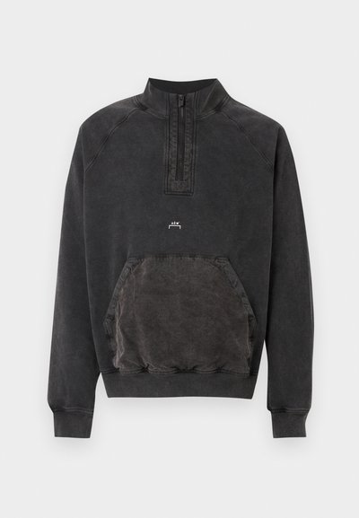 Μαύρο φούτερ με μισό φερμουάρ, τσέπη καγκουρό, ριμπ περιλαίμια και μανσέτες, και μικρό λογότυπο "A C W" στο στήθος.