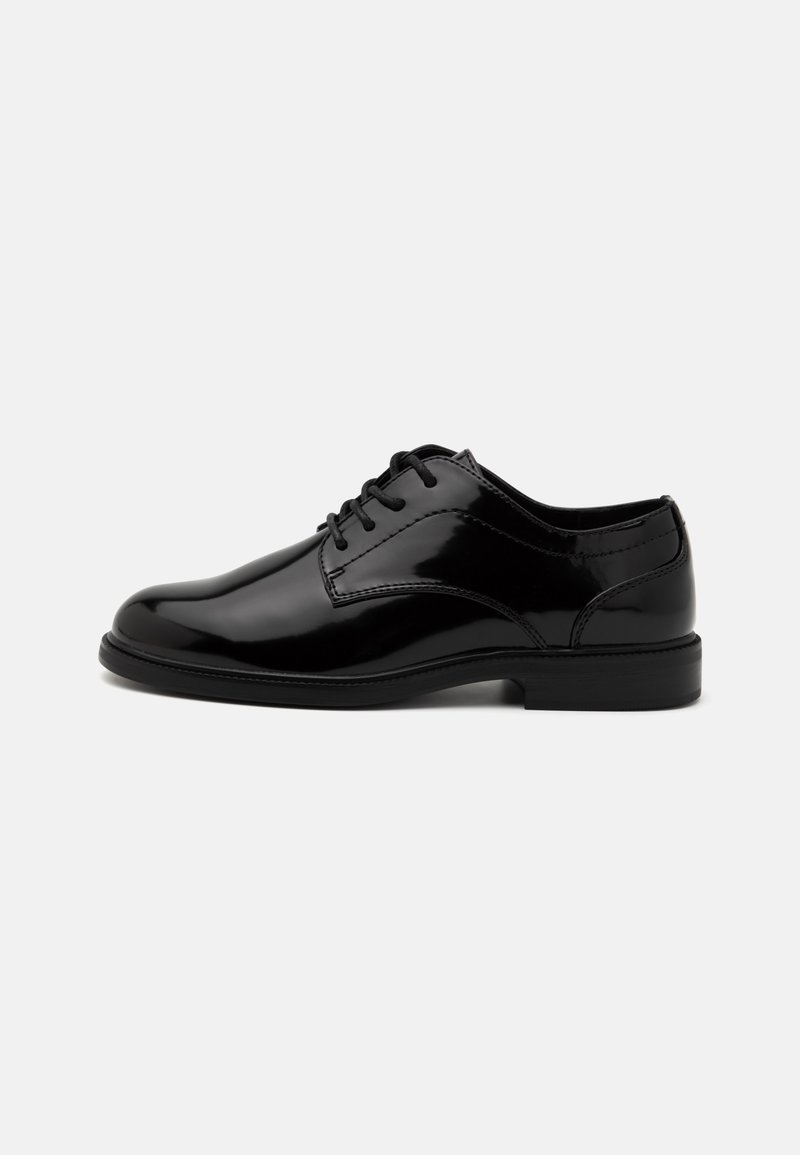 Chaussures habillées en cuir verni noir avec un bout arrondi, un laçage et une surface lisse. Elles ont un petit talon en caoutchouc noir et des détails cousus.