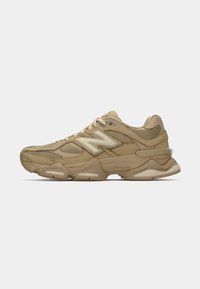 Chaussure de sport beige avec des panneaux en maille superposés et en daim, bout arrondi, semelle épaisse et logo contrastant. Comprend des lacets et un col rembourré.