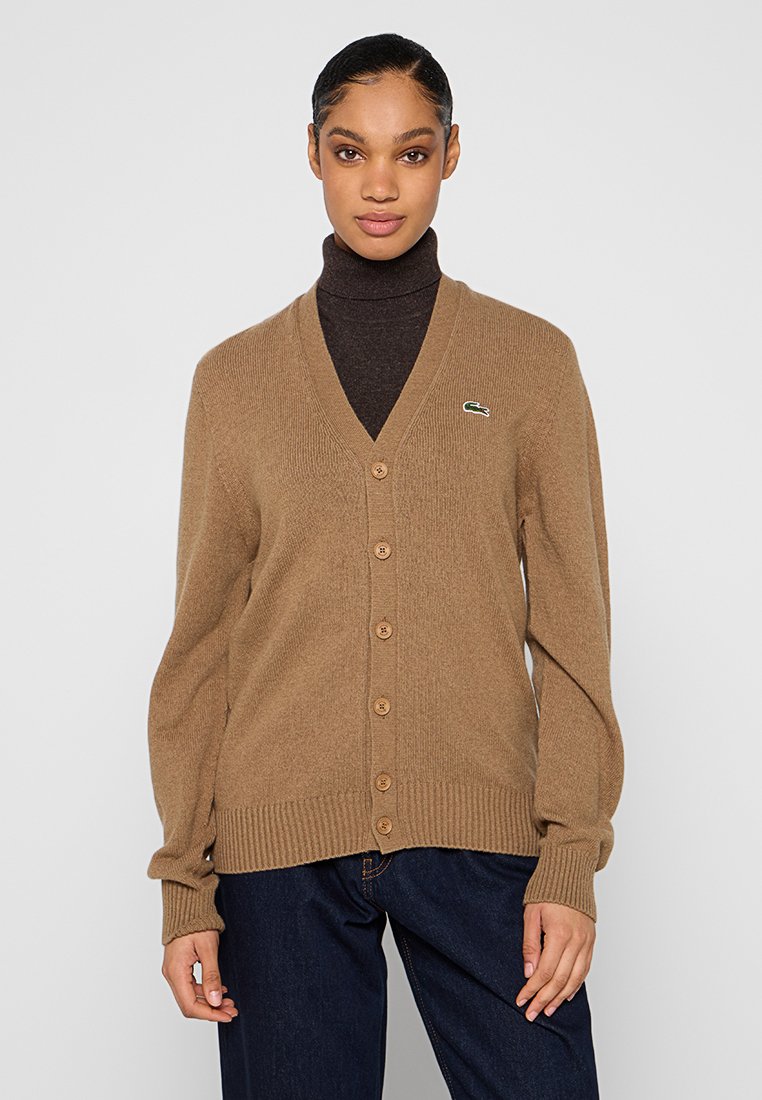 Cardigan en mélange de laine marron avec un col en V, fermeture à boutons, poignets et ourlet côtelés. Présente un petit logo vert sur la poitrine gauche.