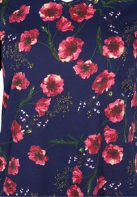 Blusa floral de tejido azul marino con flores de amapola rosas, tallos verdes y pequeños acentos blancos, con un diseño de escote en V. Textura suave.