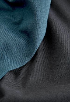 To lag af stof, den ene mørk sort og den anden dæmpet teal. Begge har en glat, let struktureret overflade, hvilket skaber en blød fald.