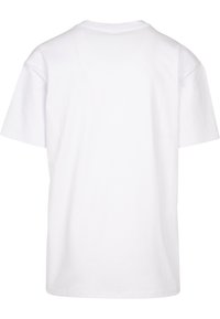T-shirt en coton blanc avec un col rond, des manches courtes et une coupe décontractée. L'arrière est uni sans graphiques ni éléments de design supplémentaires.