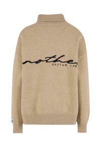 Beżowy sweter z dzianiny z wysokim kołnierzem, ściągaczami na mankietach i u dołu oraz czarnym kursywą napisem "nother Cotton Lab" na klatce piersiowej.