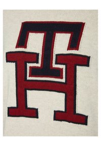 Sweter dzianinowy w kolorze ecru, z dużym czerwonym i granatowym logo. Gładka tekstura z kontrastowymi akcentami kolorystycznymi w odważnym wzorze.