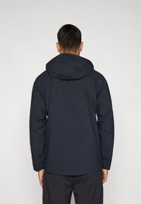 Marineblå isoleret jakke med hætte, lange ærmer og elastiske manchetter, med en glat tekstur og minimalistisk design.