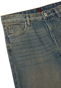 Vaqueros de mezclilla en azul desgastado, con cierre de botones, trabillas para cinturón, cinco bolsillos y una ligera textura con detalles de costura en contraste.