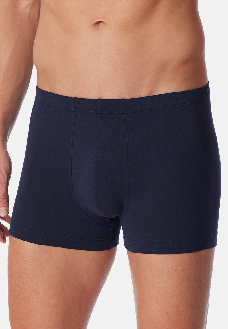 Boxers en coton bleu marine avec une ceinture élastique, offrant une coupe ajustée et une texture lisse. Design simple sans motifs ni accents supplémentaires.