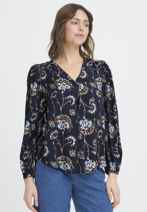 Bluse mit Blumenmuster in Marineblau, mit Puffärmeln, V-Ausschnitt und strukturierter Stoff mit beigen und blauen Blumen auf gestreiftem Hintergrund.