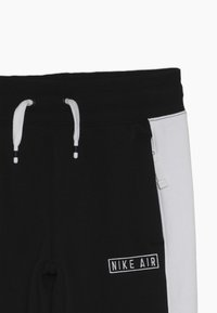 Svartvitt sweatpants med dragsko i midjan, sidofickor och "NIKE AIR"-logotyp i vit brodering på framsidan, i blandmaterial av bomull.