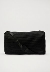 Black mesh duffel bag with a textured diamond pattern. Features a long adjustable strap and a rectangular shape. Embossed detailing present.