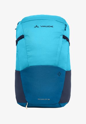 Heldere blauwe en turquoise Vaude Skomer Zip 22 rugzak met zijbanden en bovenste rits op een witte achtergrond.