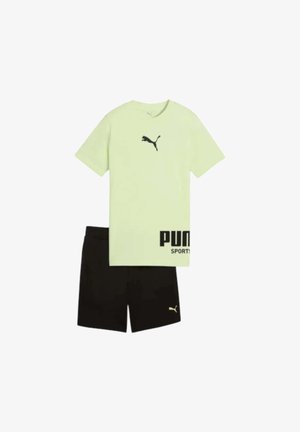 Camiseta Puma de color verde claro con logo negro de Puma y pantalones cortos negros con pequeño logo de Puma en la pierna izquierda.