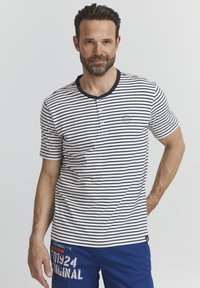 Camiseta henley de manga corta en rayas azul marino y blanca, con un cuello redondo de tres botones y un pequeño logo bordado en el pecho.