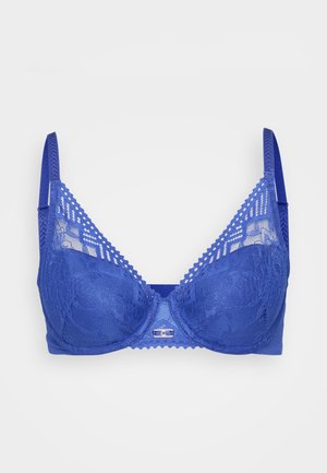 Reggiseno in pizzo blu con design strutturato, caratterizzato da bordi ondulati, spalline regolabili e un piccolo gancio metallico al centro davanti.