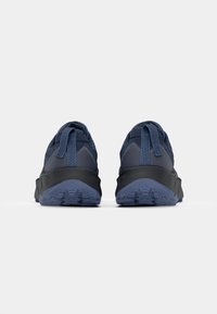 Chaussures de plein air bleu marine avec une tige en maille texturée, un talon renforcé et une semelle en caoutchouc noir dotée de motifs de crampons agressifs.