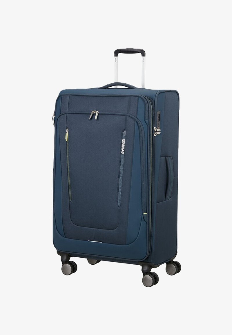 Valise souple bleu marine avec poignée télescopique, poches avant zippées, poignée latérale et quatre roues pivotantes pour une mobilité facile.
