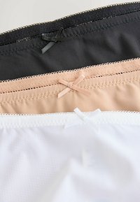 Drie paar naadloze ondergoed in zwart, nude en wit. Elk model heeft een decoratieve strik op de tailleband en een gestructureerde afwerking.