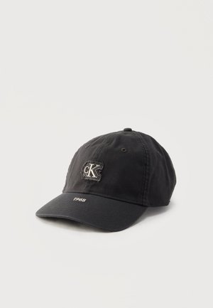Black baseball cap with "cK" logo patch on front and "1968" embroidered on the brim, set against a plain light background.