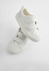 Hvide sneakers med en glat læderoverdel, to velcro-stropper, gummisåler og subtile syninger. Designet med en afrundet form.