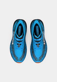 Blue athletic shoes with a textured surface, featuring a black and blue splatter pattern, lace-up design, cushioned sole, and orange accents.