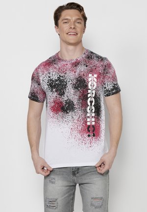 White t-shirt with a splatter pattern in red, black, and grey. Features bold "Koss" text in white along the side. Short sleeves and round neck.