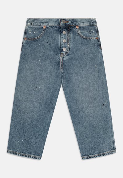 Pantalones vaqueros de denim azul con un corte holgado, cuatro botones de metal en el frente y un acabado desgastado con pequeñas manchas de pintura.